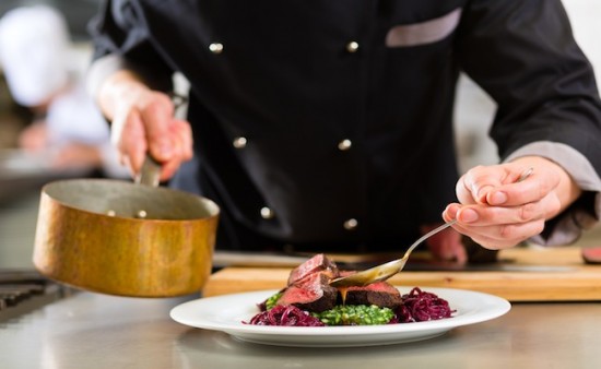 Chef in hotel or restaurant kitchen cooking