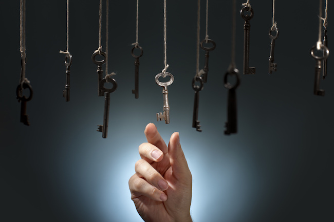 Hand choosing a hanging key amongst other ones.